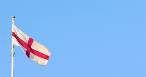 English Flag Waving Against a Clear Blue Sky