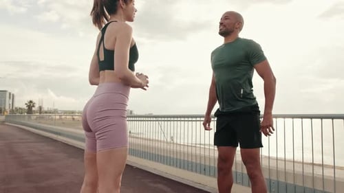 Athletic Woman and Man Squatting Together Outdoors