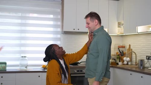 Affectionate Woman Touching Man's Face in Kitchen