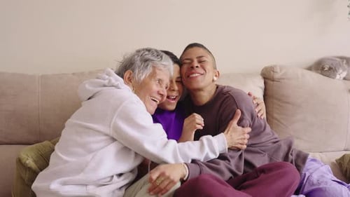 Three Family Members Laughing and Embracing on Sofa