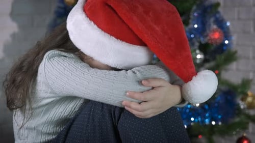 Upset Child Sits on Floor at Christmas