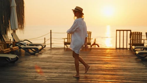 Slender Woman in White Shirt Walking to Edge of Pier and Rising Hands Up Lady Admiring Sunset or