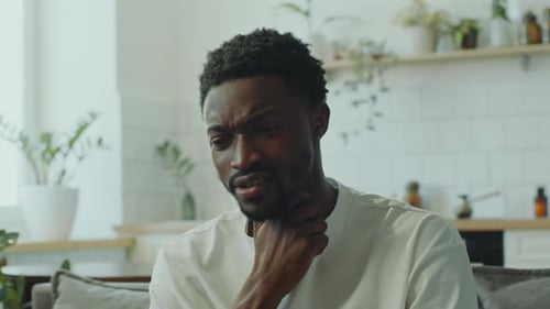 Man Coughing and Rubbing his Throat