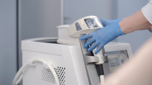 Beautician Adjusting Laser Hair Removal Machine in Clinic