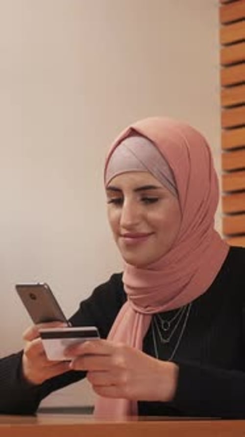 Woman Uses Smartphone With Credit Card, Close Up