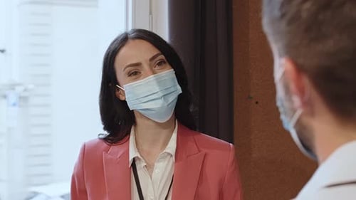 Woman Talks with Colleague Wearing Masks in Office