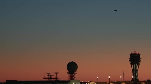 Kontrollturm am Abend und Flugzeug in der Ferne