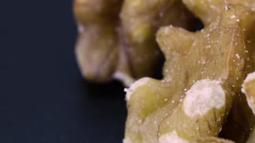 shot of peeled walnuts, extreme close up zoomed image, black background.