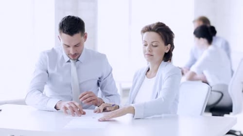 Happy business partners signing a contract in the office with optimism
