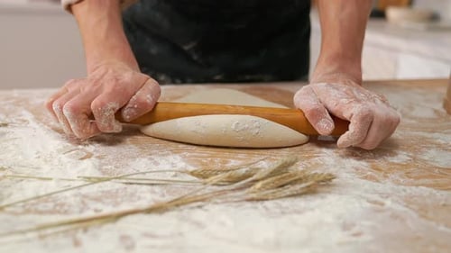 Baker Rolling Dough with Rolling Pin at Home