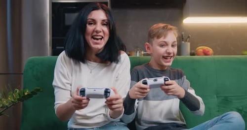 Excited Mother and Son Playing Video Games at Home