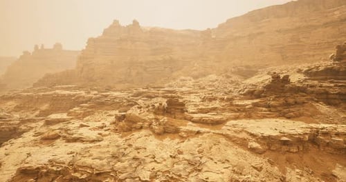 Exploring the Vast and Rugged Terrain of a Desert Landscape Under Hazy Skies