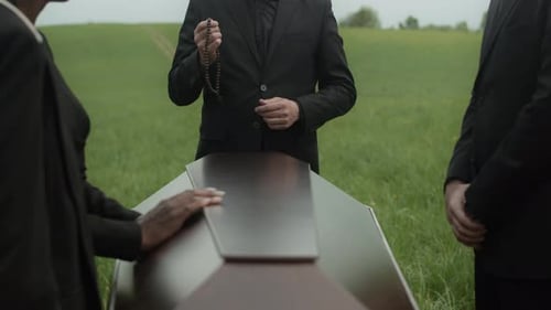 Mourners Gathered Around Casket in Grassy Field