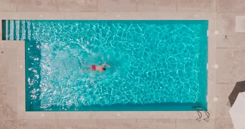 Aerial View As a Man Swims in the Pool
