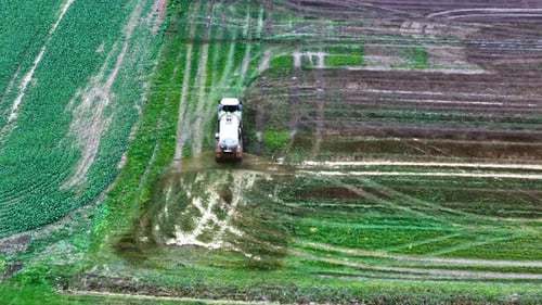 Agricultural Truck Spraying Chemical Solutions On Farming Field. aerial, rear shot