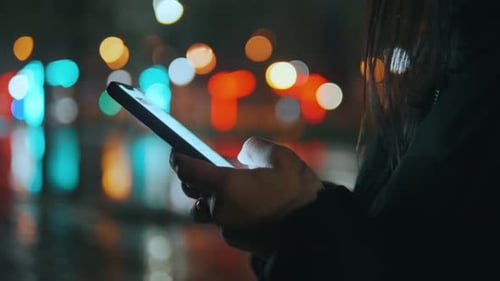 Closeup Shot of Woman Hands with Smartphone in the City at Night