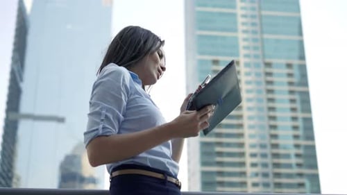 Young, Pretty Businesswoman Working with Tablet and Smartphone Standing on Terrace 30s