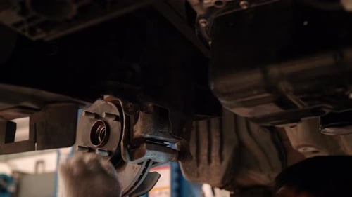 Car Mechanic Working Under a Vehicle