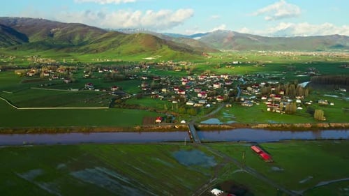 A large, lush green field with a dirt road running through it