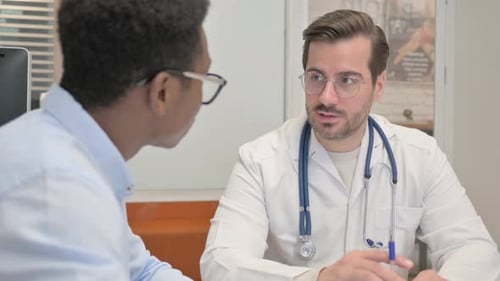 Close up of Doctor Discussing Medical Report with Patient in Clinic