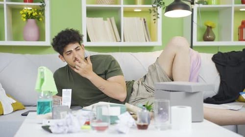 Man Lying on Sofa Applying Cream to Face