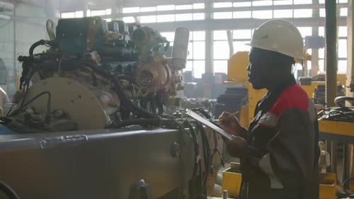 Technician Inspecting Heat Engine at Machinery Plant