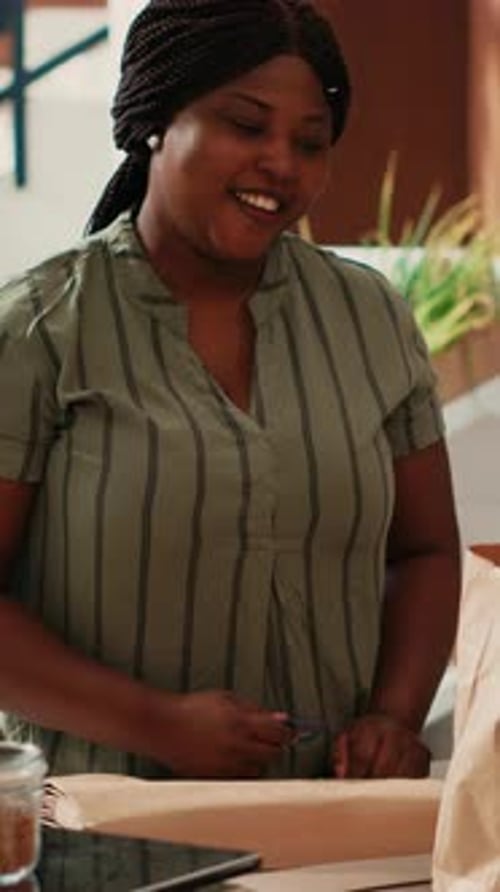 Woman Completes Transaction With Customer at Store