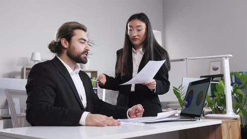 Woman Arguing with Man About Paperwork Failure in Office