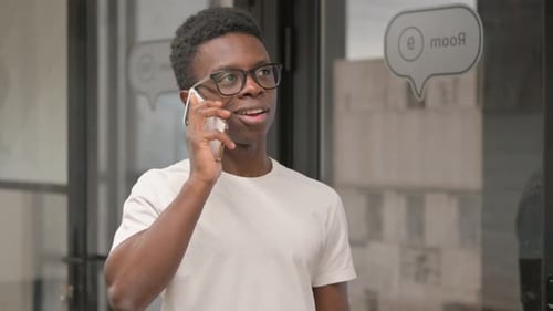 Young Adult Talks on Smartphone in Office Setting