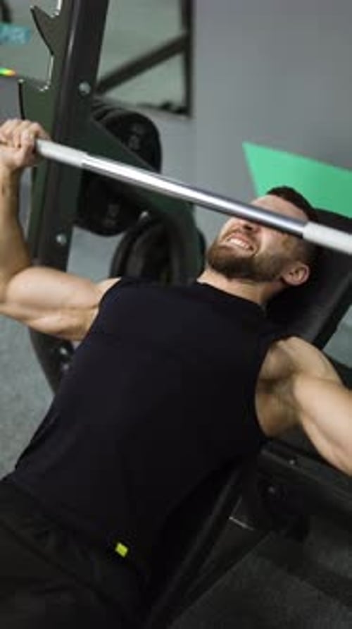 Men Working Out Barbell Bench Press in the Gym