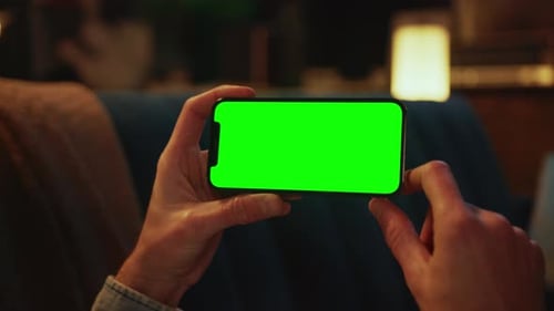Close Up Hands Using Typing on a Mobile Phone with a Horizontal Green Screen Lying on a Sofa Social