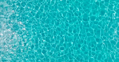 Blue Water in the Swimming Pool with Light Reflections