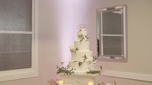 Beautiful Backlit White Multi Tiered Wedding Cake at a Reception Hall.