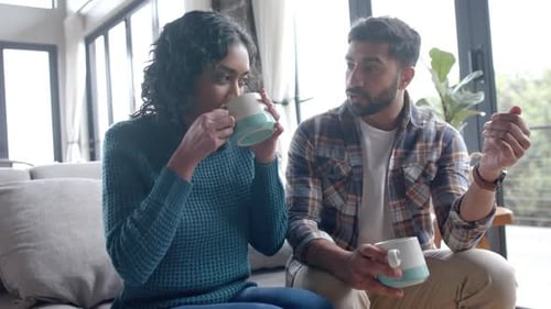 Young Adult Couple Talking and Drinking Indoors