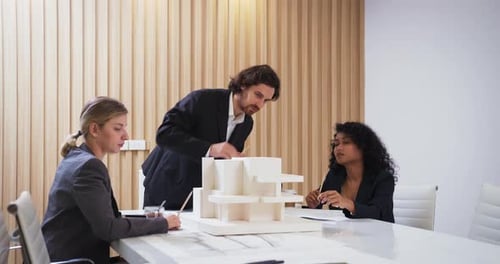 Team Discussing Architectural Model in Modern Office