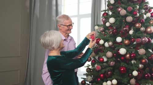 Senior Couple Decorating Christmas Tree with Love