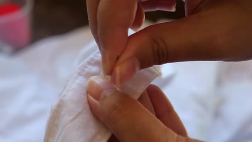 Close Up of Woman Hands Sewing a Button