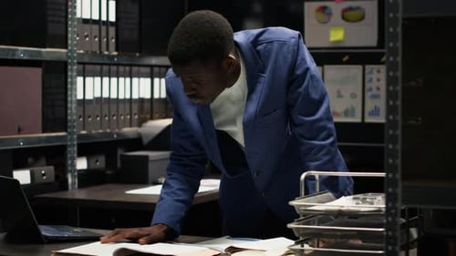 Adult Working at Desk in Dim Office