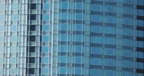 Tilt shot of modern skyscrapers with a glass facade in business district.