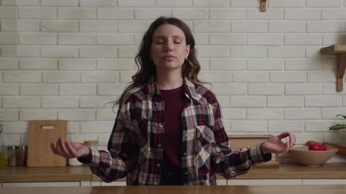 Woman Meditating Peacefully at Kitchen Counter