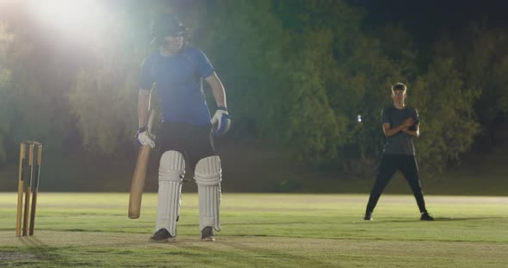 Male batsman on cricket pitch responding to bowler's run-up by driving ...