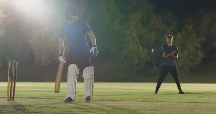 Male batsman on cricket pitch responding to bowler's run-up by driving ...