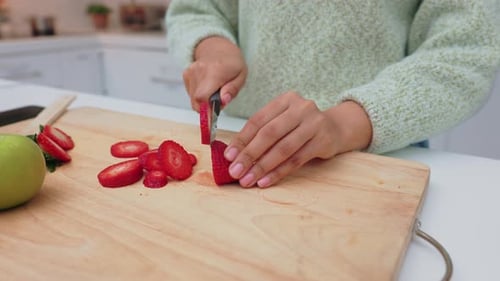 Woman Slicing Fresh Strawberries in Bright Kitchen