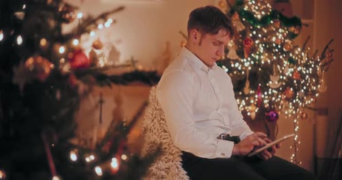 Man Using Digital Tablet at Decorated Home During Christmas
