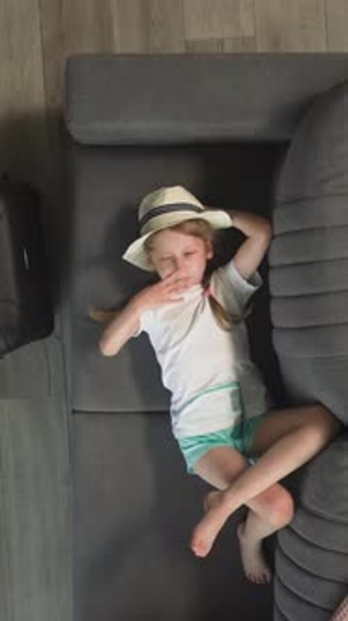 Girl Relaxing on Couch While Boy Plays