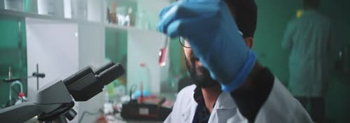 Scientist Viewing Sample Through Microscope in Lab