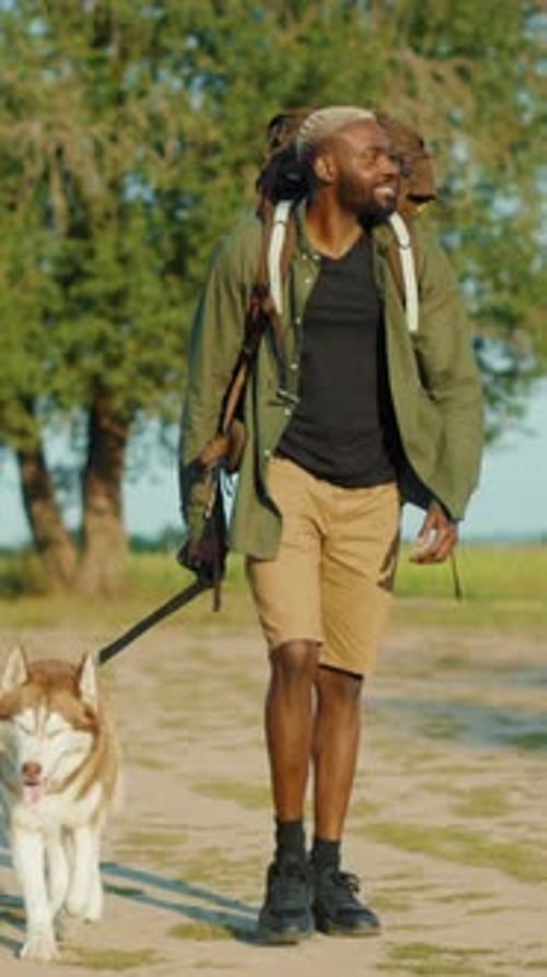 A Man Enjoys a Leisurely Walk with His Dog While Exploring a Beautiful Nature Trail