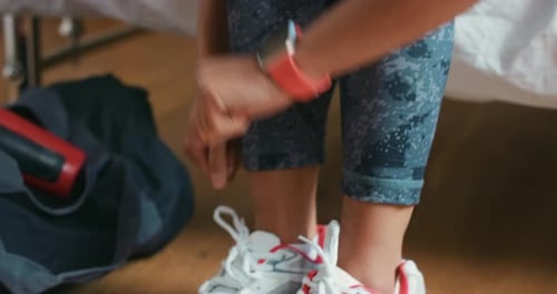 Adult Tying Shoe Laces and Checking Smartwatch
