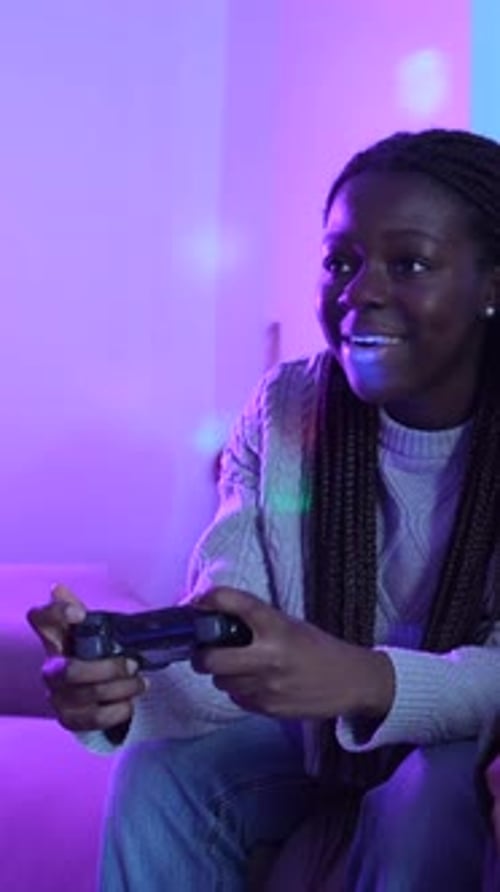 Two Friends Gaming on Cozy Sofa at Night