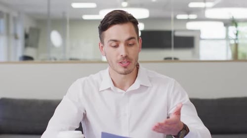 Caucasian businessman having video call at office, slow motion